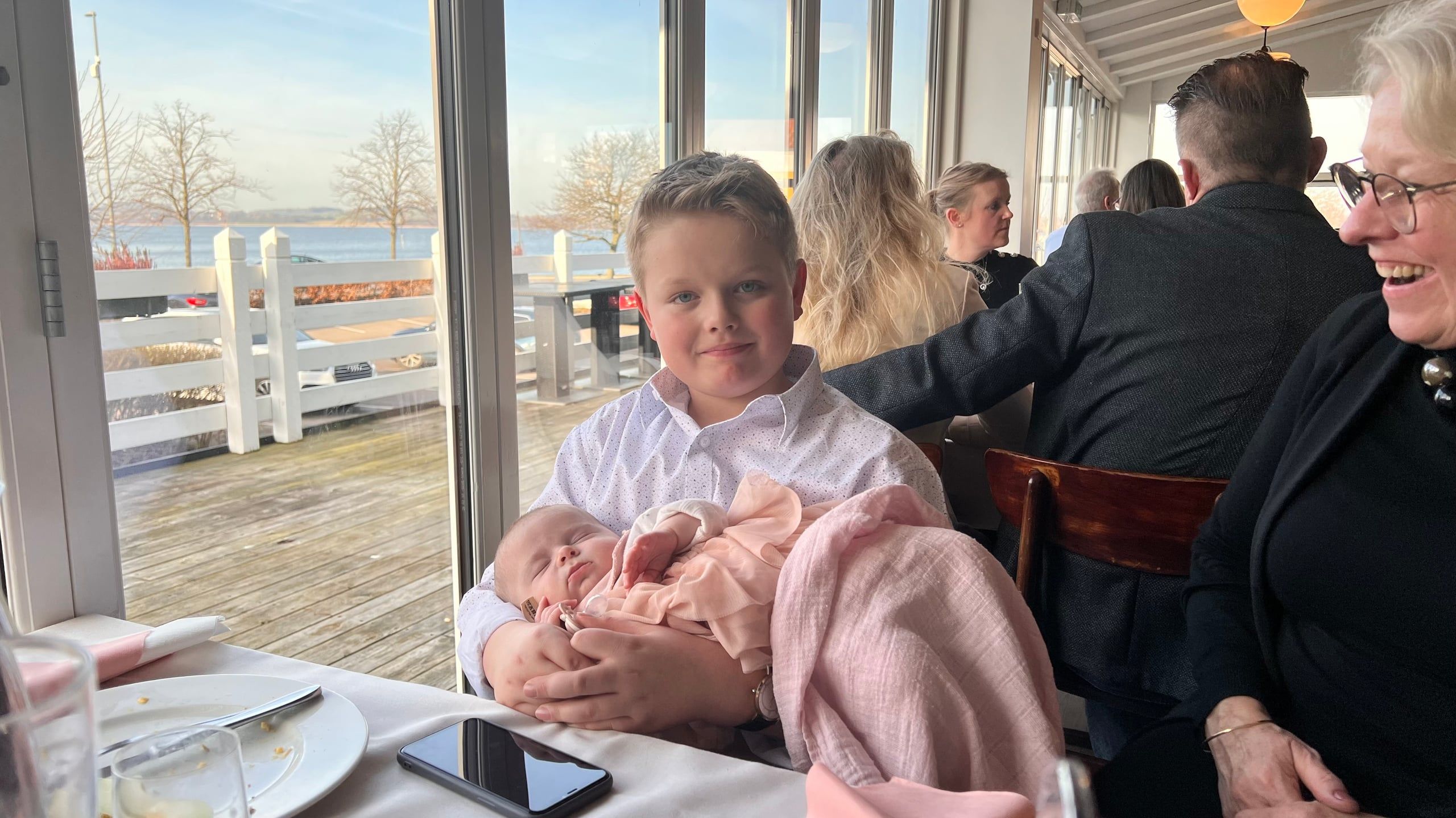 Noah holder en sovende baby ved et festbord